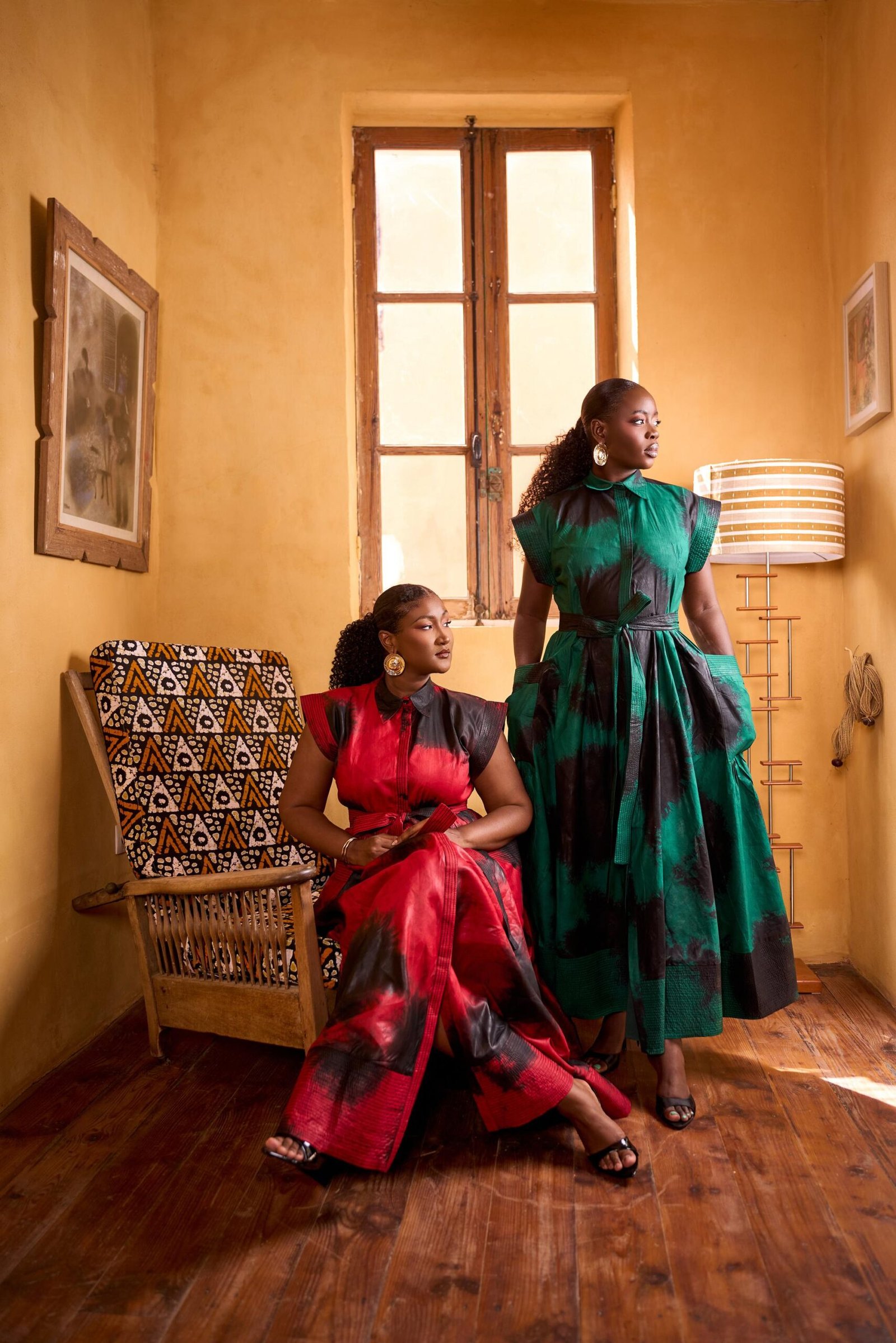 Duo Thiane, kaftans batik rouge et vert dans un intérieur ocre
